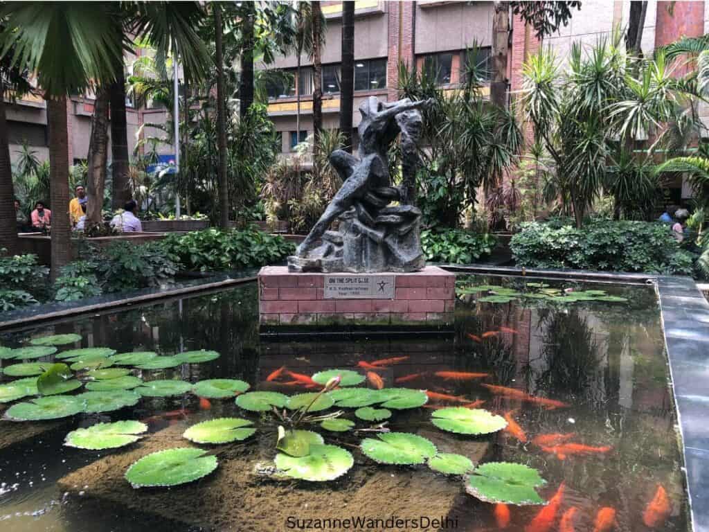 one of the public art pieces on display in a lotus pool with koi in the India Habitat Centre atrium, one of the best ways to get cultural in Delhi