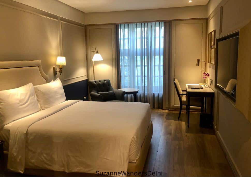 interior of guest room with king size bed, desk and arm chair at Radisson Blu Marina in Delhi