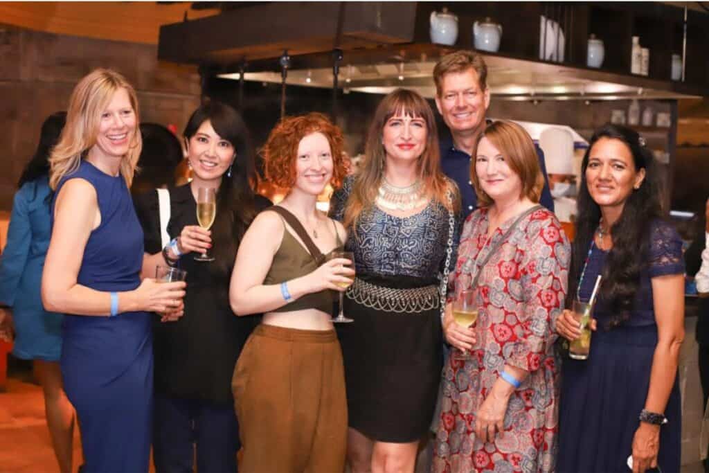 A group of six women and one man holding drinks inside a bar at an Internations event in Delhi, one of the best social networks for expats