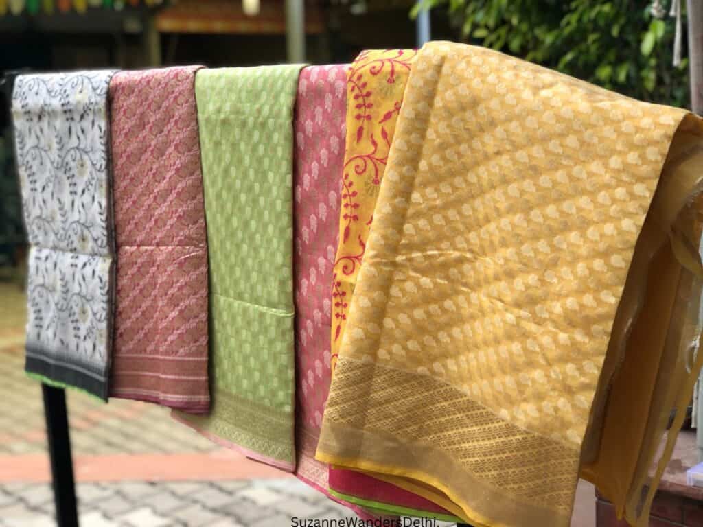 A selection of hand woven shawls on display at Dastkar Nature Bazaar, one of the best places for authentic souvenirs and gifts in Delhi