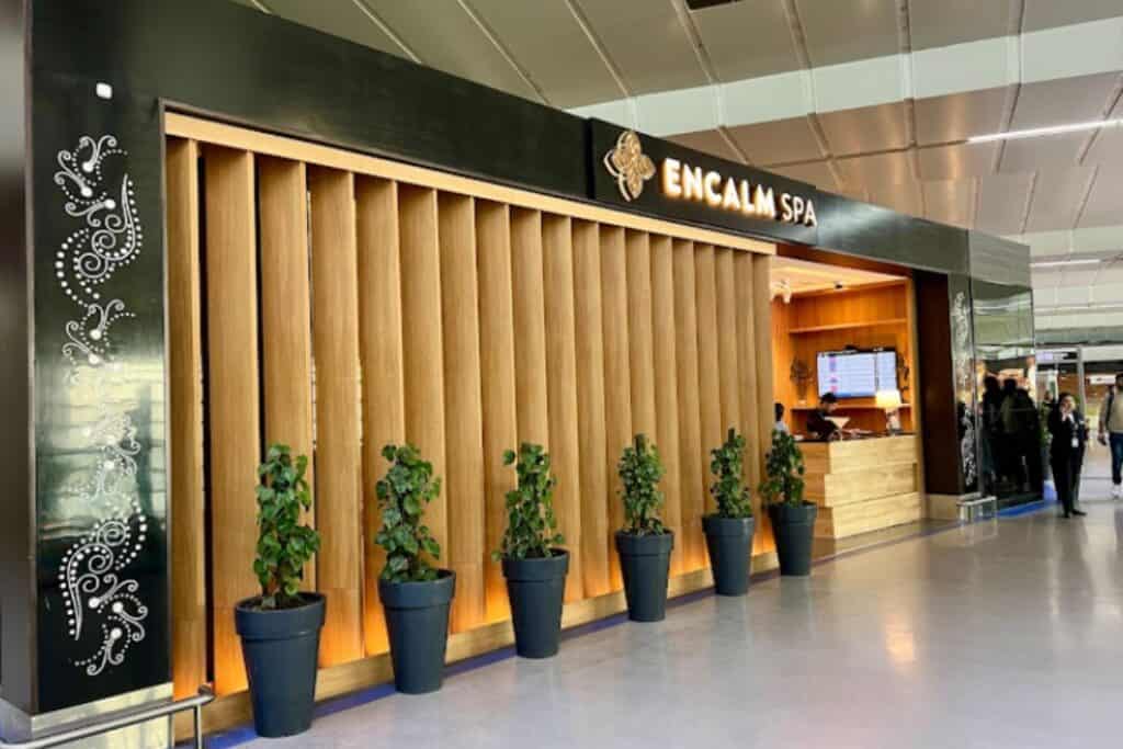 Exterior view of Encalm Spa in Delhi Airport Terminal 3 with 5 potted plants in front