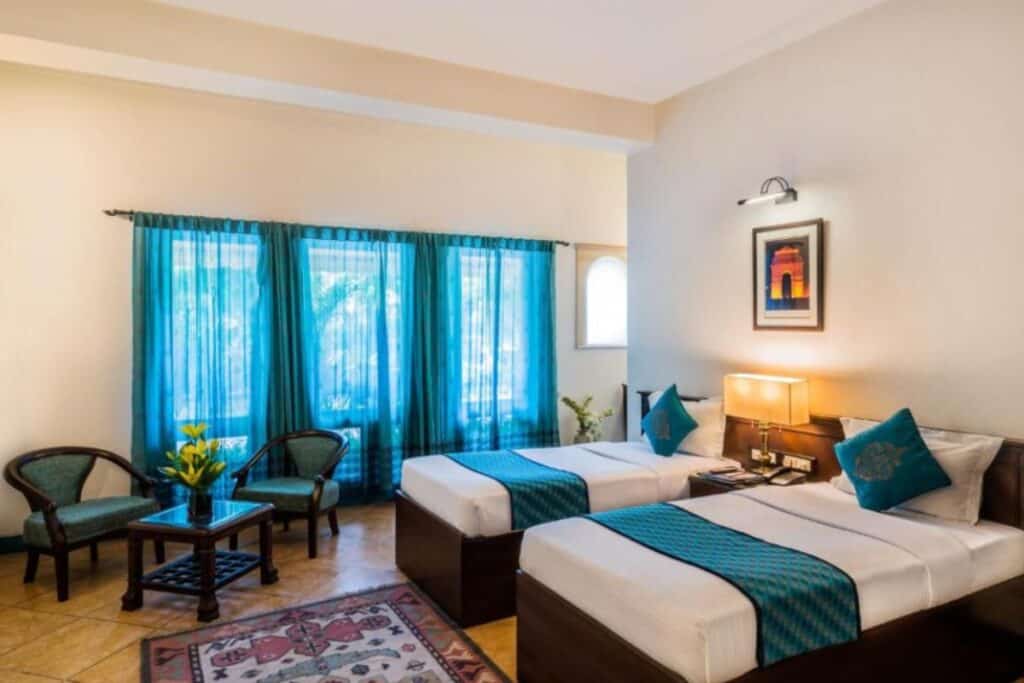 twin room with blue curtains at Home@F37, one of the best budget South Delhi hotels