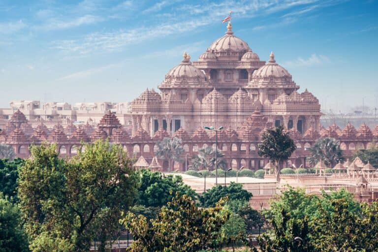 side view of Akshardham Temple looking pink with green trees