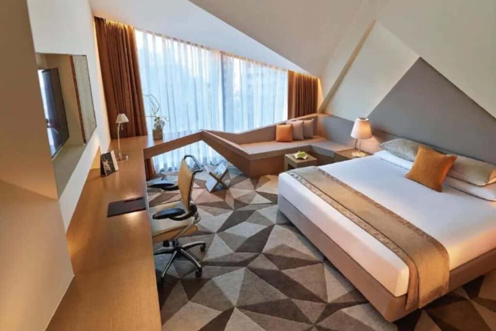 geometrical pattern carpeting and king size bed in Vivant New Delhi, Dwarka hotel room by the airport