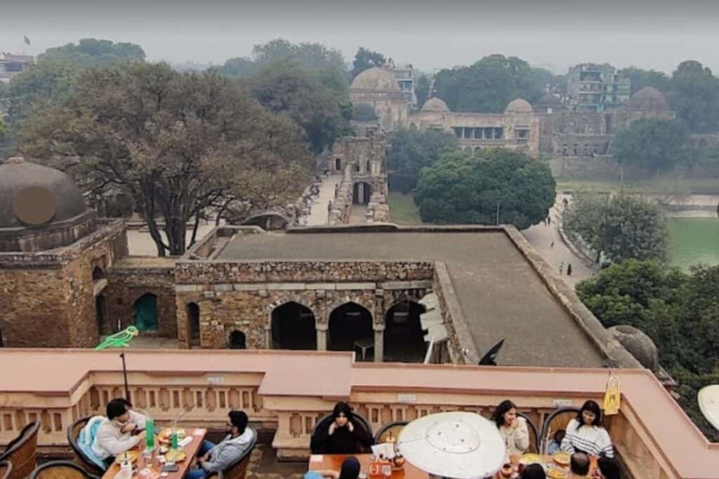 the outdoor terrace at Hauz Khas Social with Hauz Khas Fort behind it