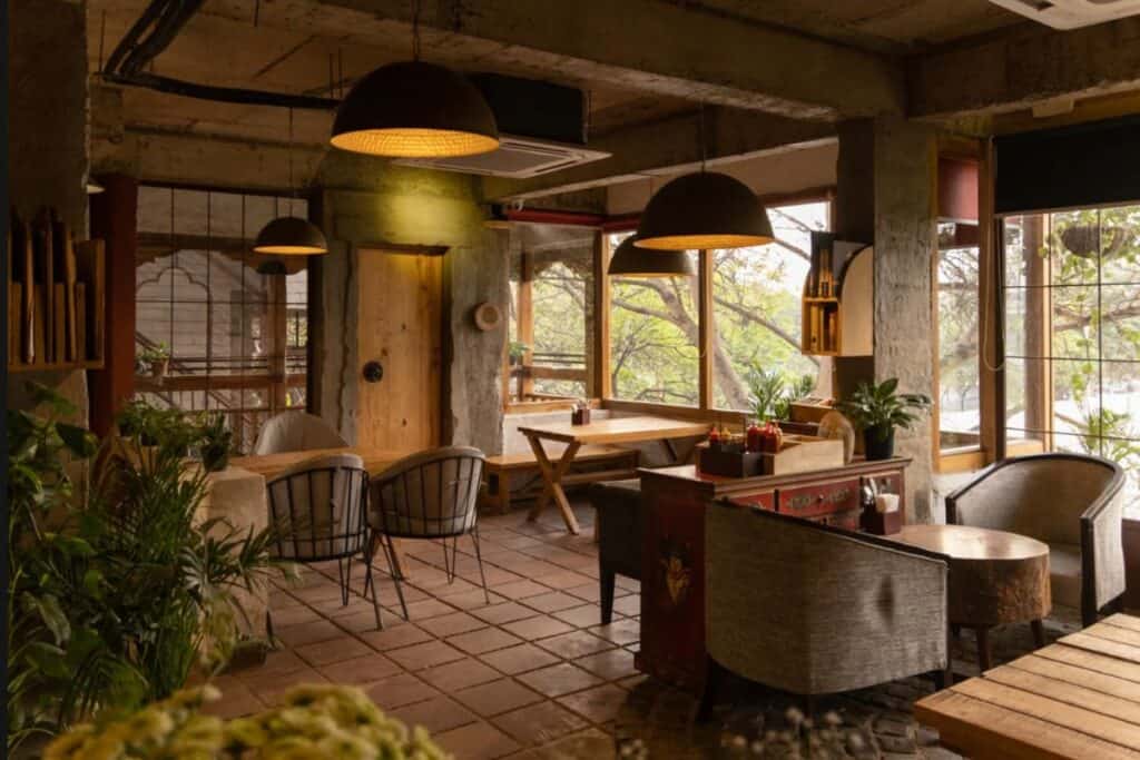 interior of AMA Cafe, the best cafe in North Delhi, with beige chairs and wooden beams