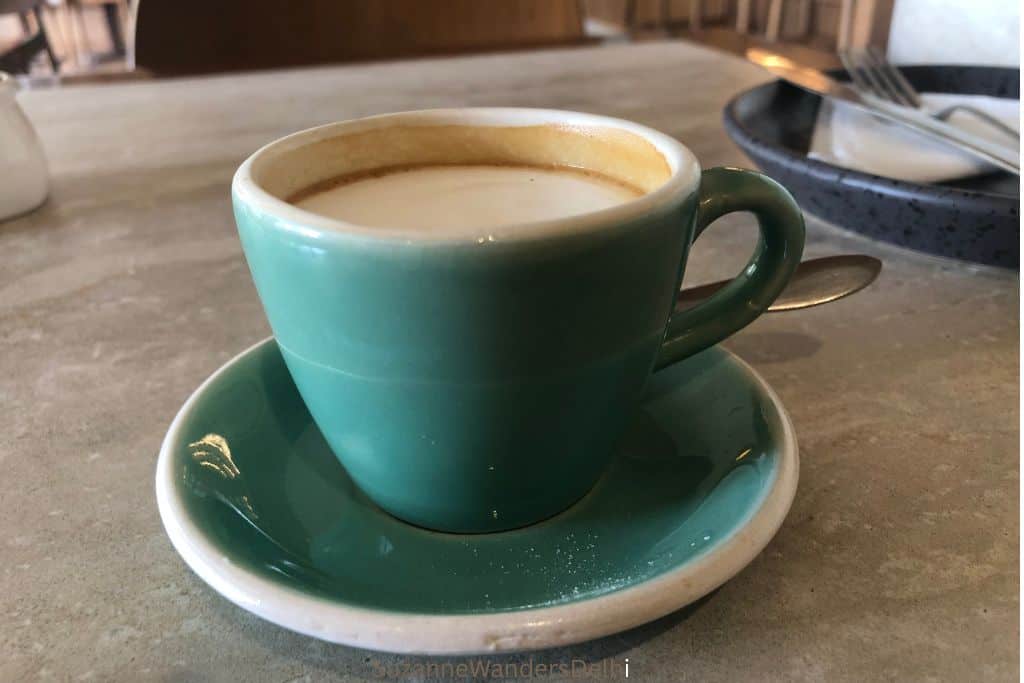 blue pottery coffee cup and saucer with a macchiato at Quick Brown Fox in Delhi