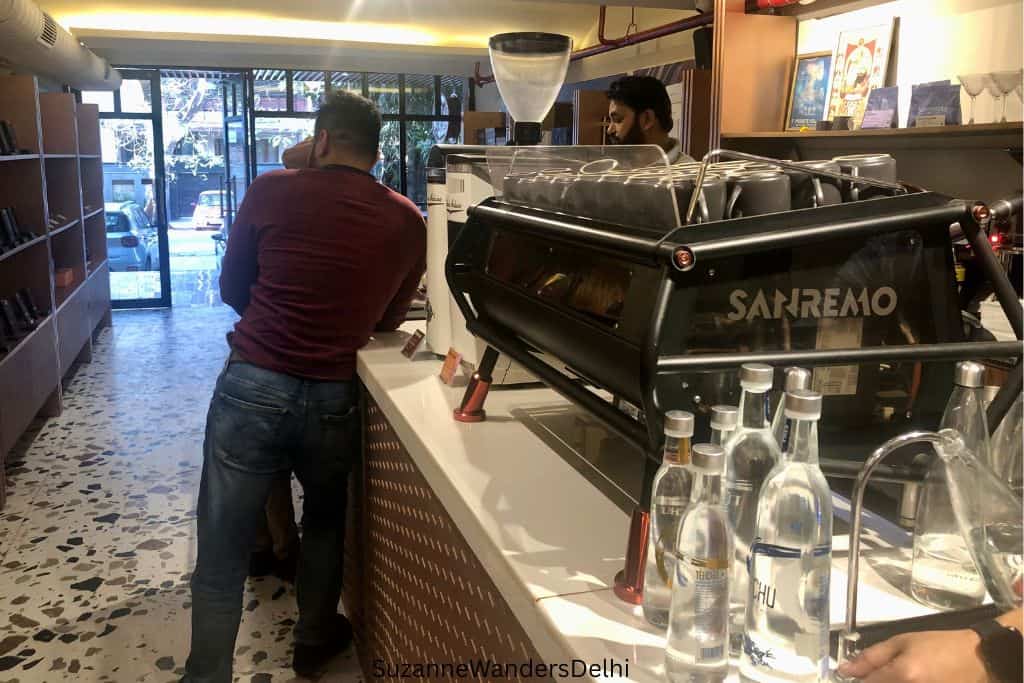 view of coffee bar with huge SanRemo espresso machine and man standing