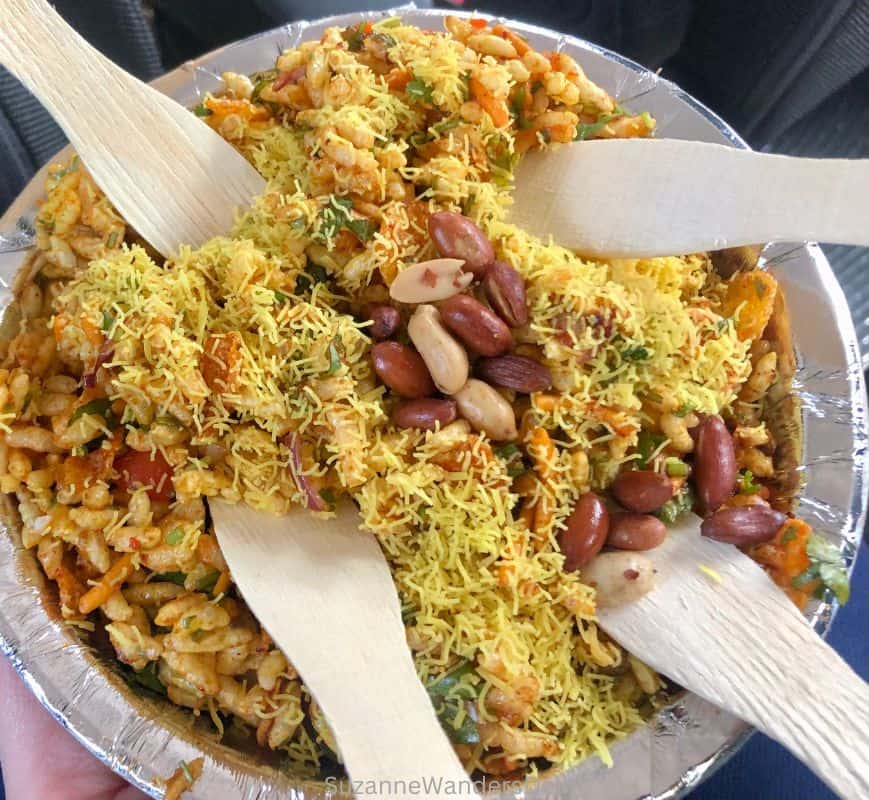 metal round plate of bhel puri with 4 wooden forks 