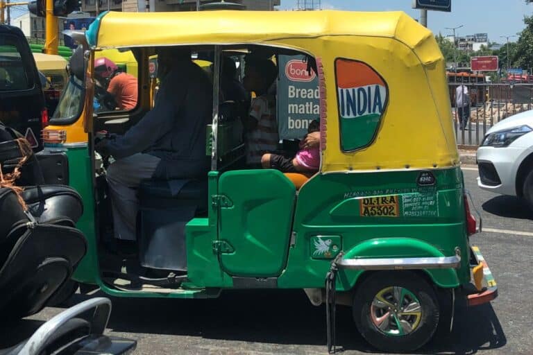 close of up of green and yellow auto rickshaw on Delhi street