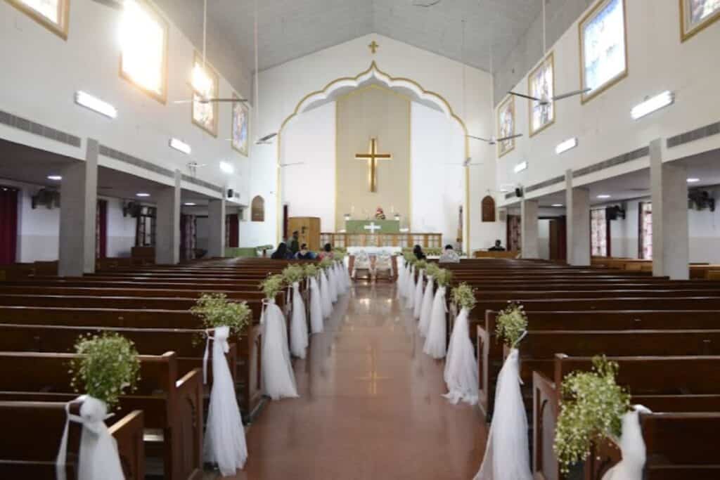 interior of Centenary Methodist Church in Delhi, famous for its Christmas Mela, with white walls and dark wood pews