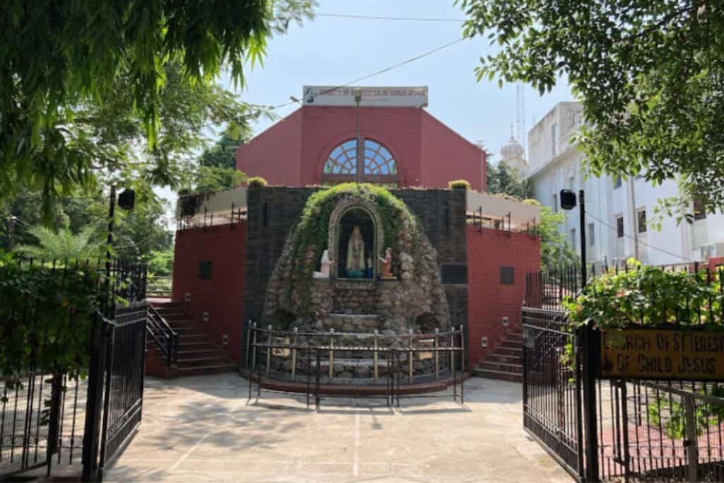 exterior of red brick church with statue of Mother of God in Delhi