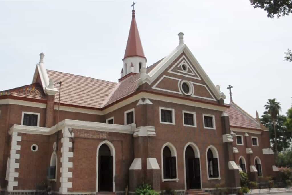 exterior long view of Christ Methodist Church with brown and white brick work and bell tower, it's famous church in Delhi