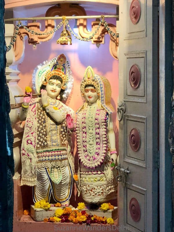 a shrine of Radha Krishna with flowers at Chhatarpur Temple