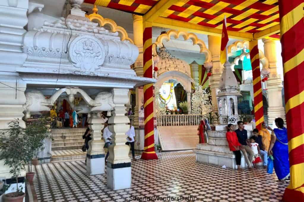 interior of Chhatarpur Tempe with black and white floor and and yellow and red decorated ceiling and columns