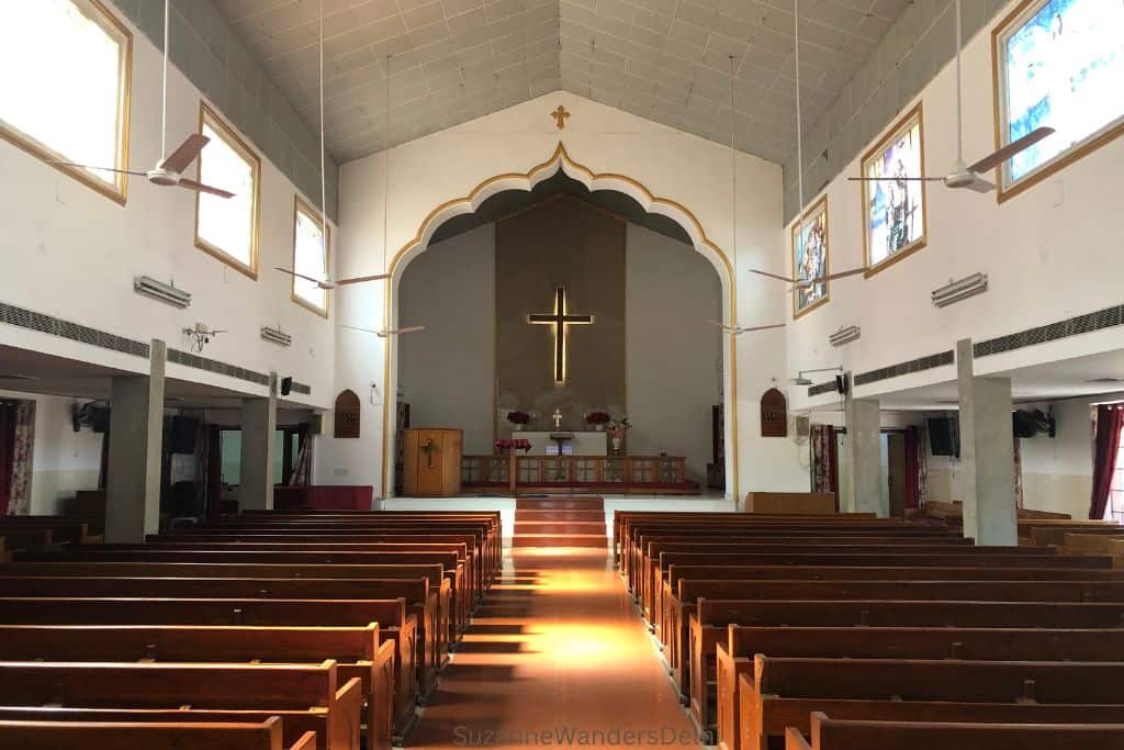 interior of Cententary Methodist Church with wooden pews and white alls and alter