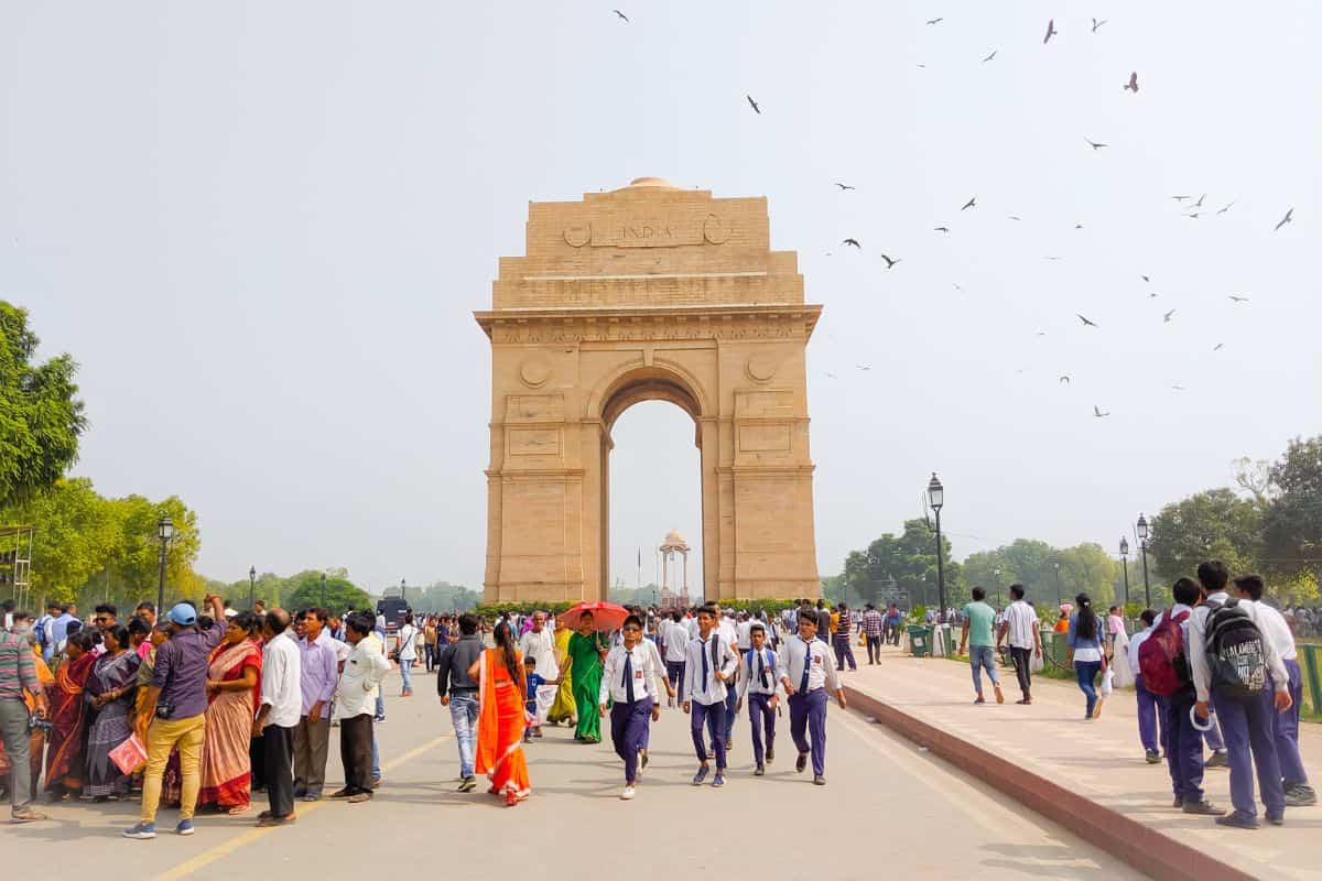 Full view of India Gate with crowds of men and women in front