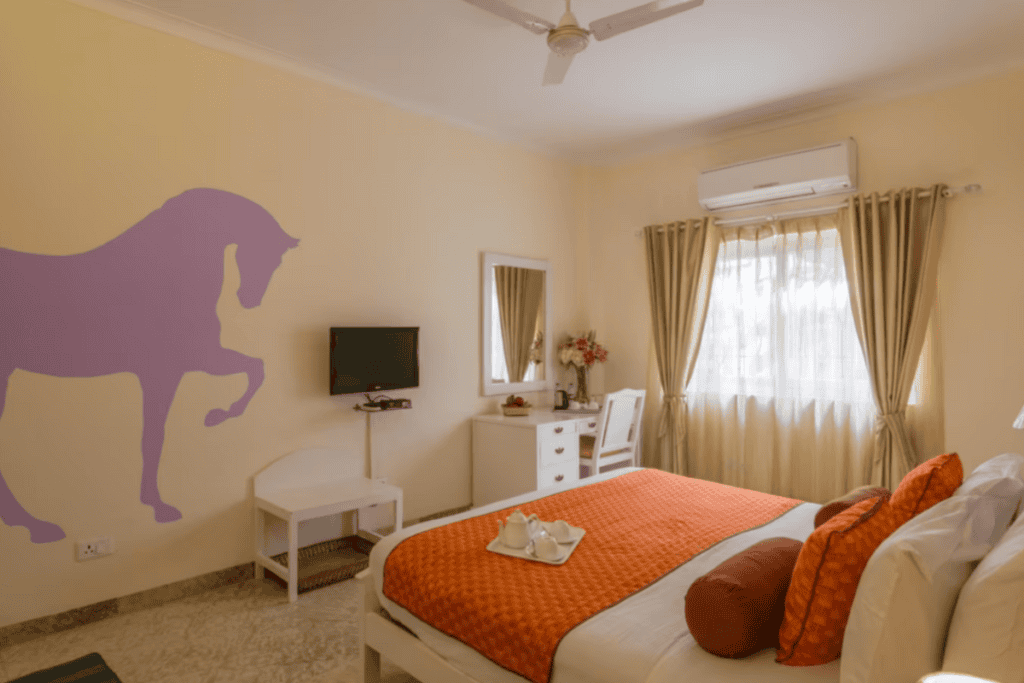 a guest room with a lilac horse painted on the wall and white bedroom furniture at Colonel's Retreat 2 in Delhi