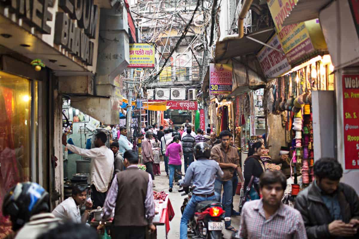 congested street with pedestrian and motorcycle traffic in Chawri Bazar, Old Delhi