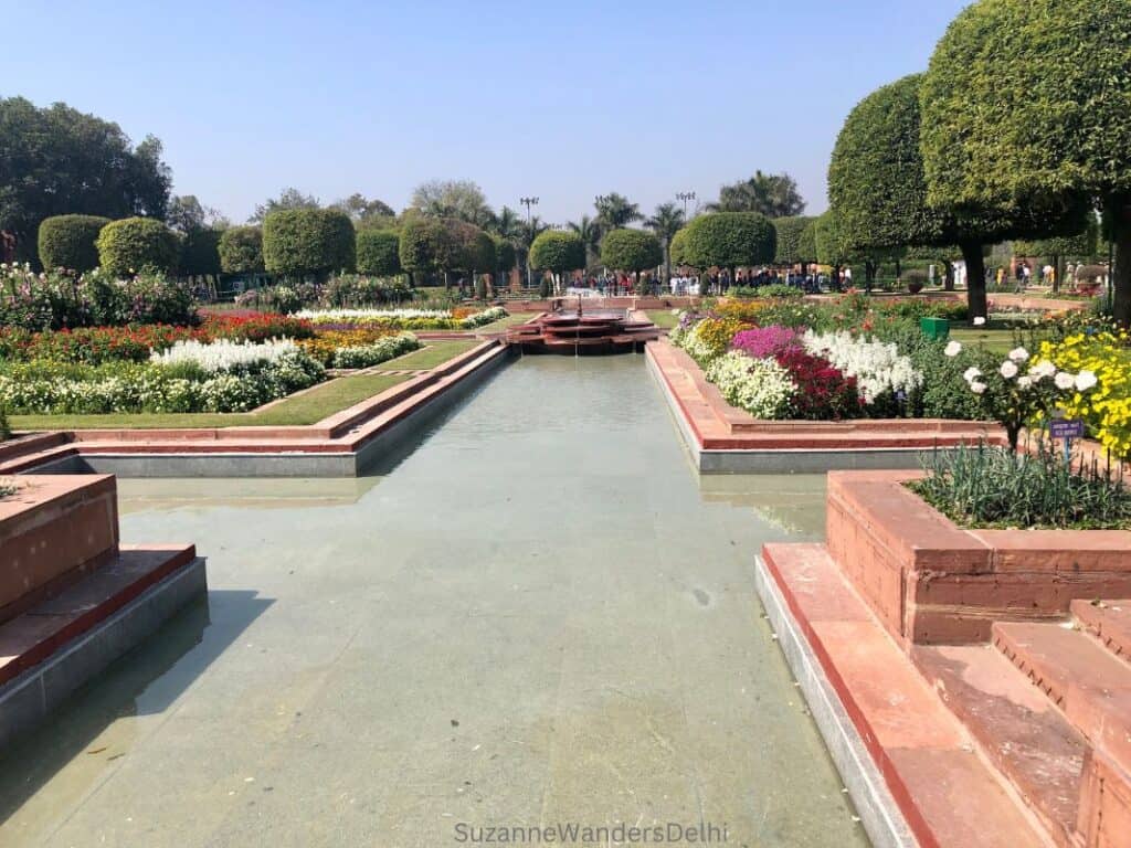 view of the blooming Mughal Gardens at Rashtrapati Bhavan in Delhi with long view of waterway and fountain in February, one of the best times to visit