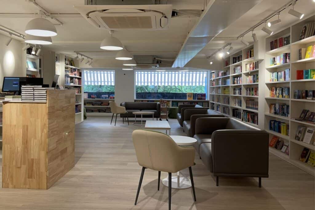 Spacious interior of Kunzum in GK II, with white organzied book shelves, grey flooring and big windows