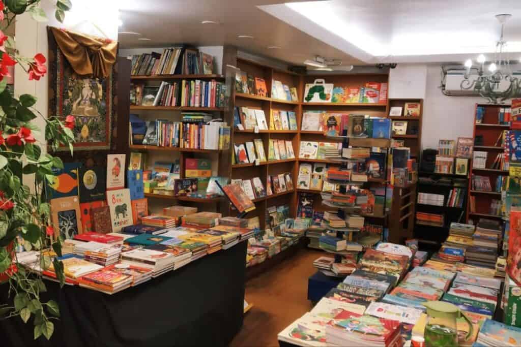 interior of Full Circle Book Store with dark wooden shelves and tables full of books, one of the best bookstores in Delhi