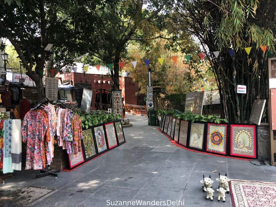 Indian clothing and artwork lining a walkway at Dilli Haat INA