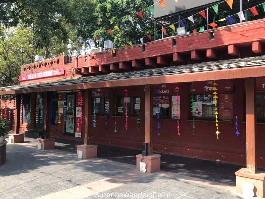 Red brick ticket booth with row of ticket windows at Dilli Haat INA 