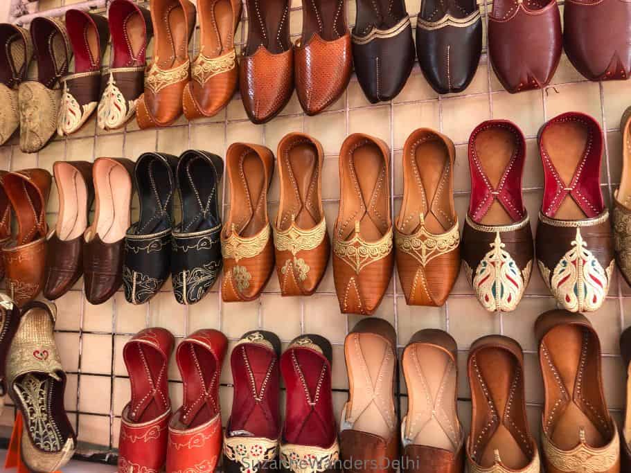 display of leather Indian shoes on wall