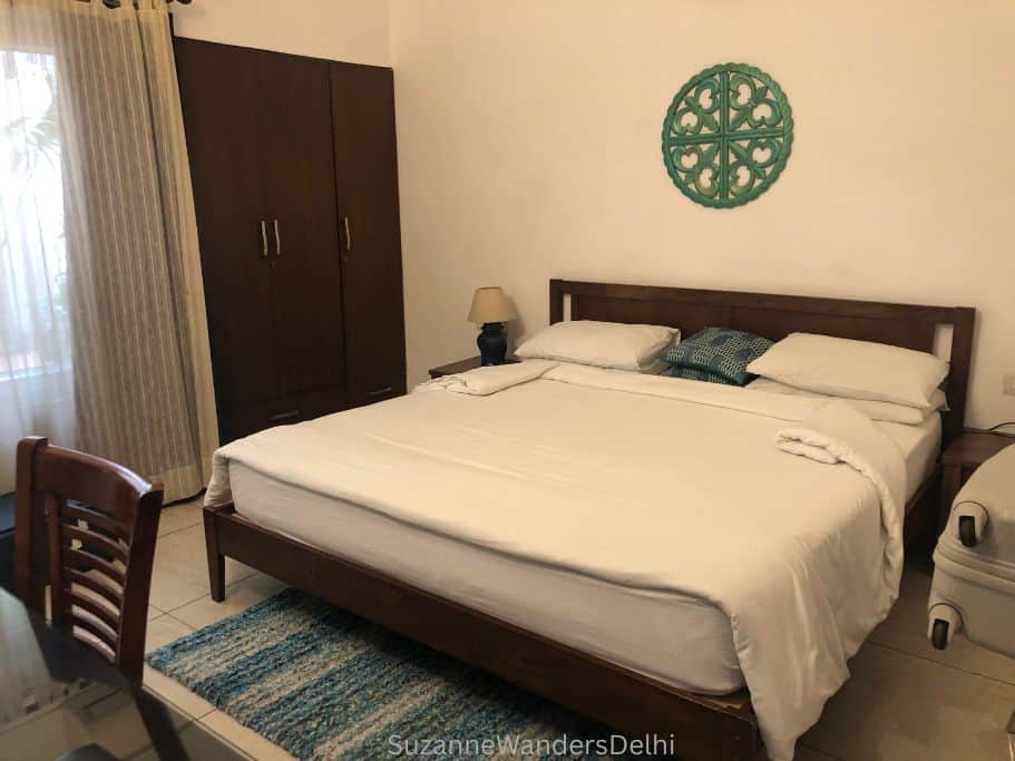 inside a guest room at the Neem with king size bed and desk