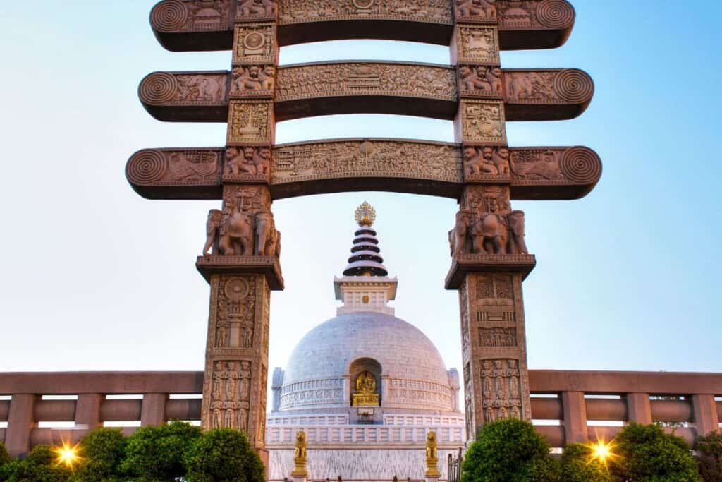 Large white marble stupa through traditional Buddhist gates in Millennium Park, Delhi