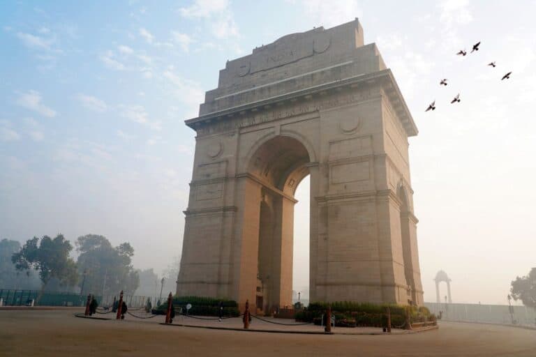 India Gate with blue sky and birds in the background