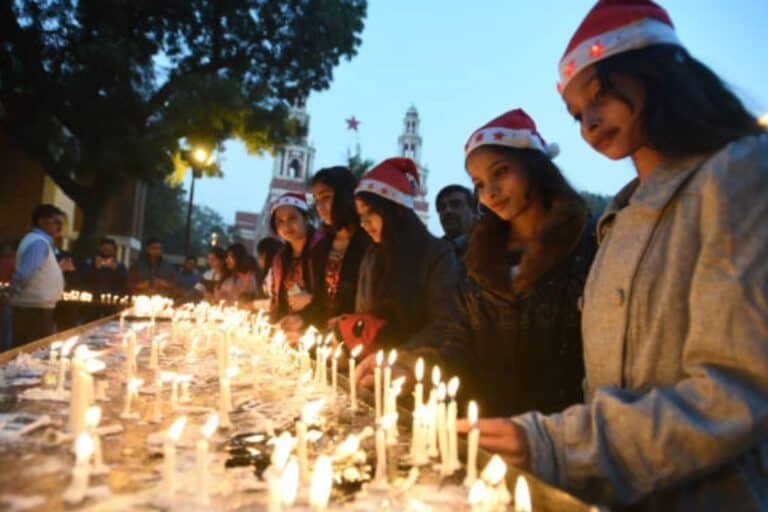 girls in Santa hats lighting candles outside Sacred Heart Cathedral in Delhi