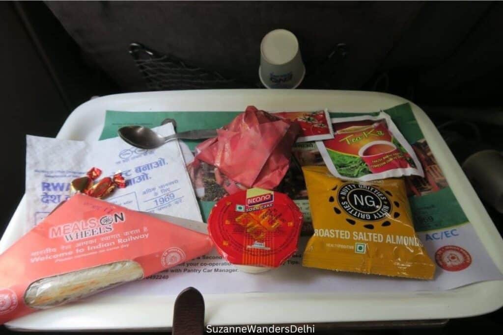 sandwich and assorted foods on white tray on Shatabdi Express train