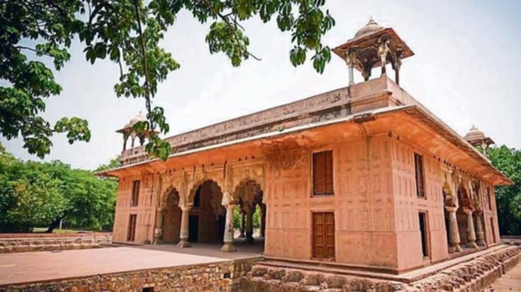 low red sandstone square building in disrepari with chaatris on each corner of the roof in Roshanara Garden in Delhi