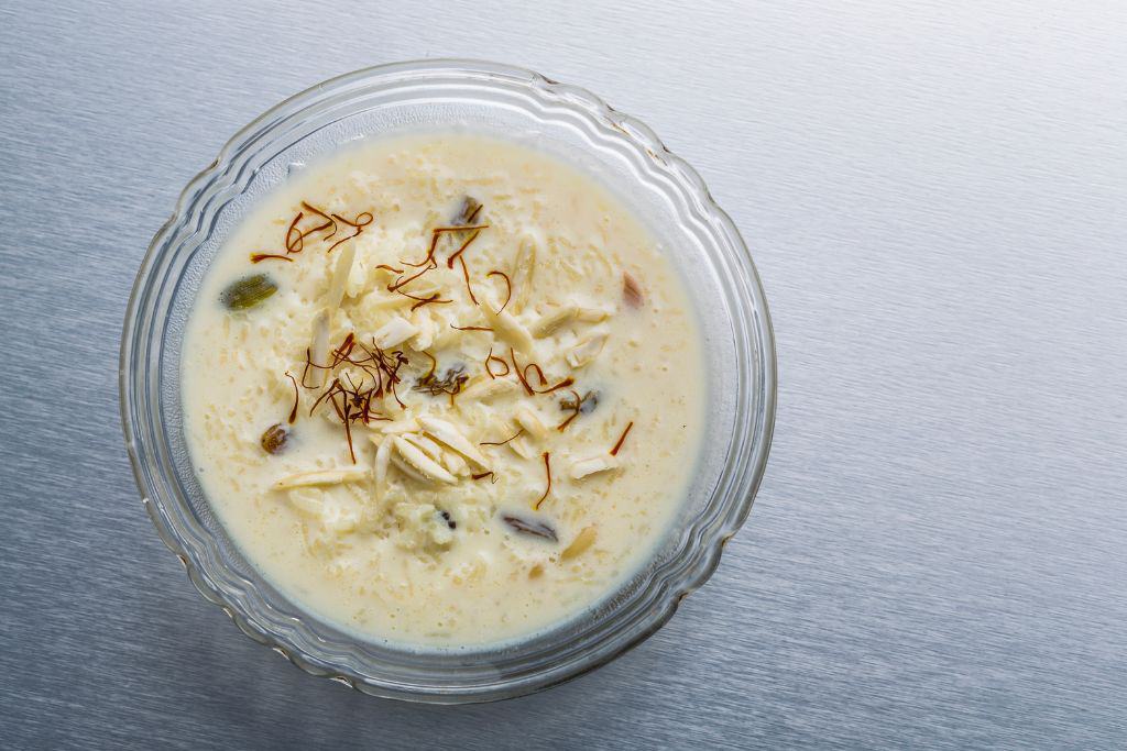 a glass bowl of kheer with nuts and saffron, one of the most famous desserts of Delhi