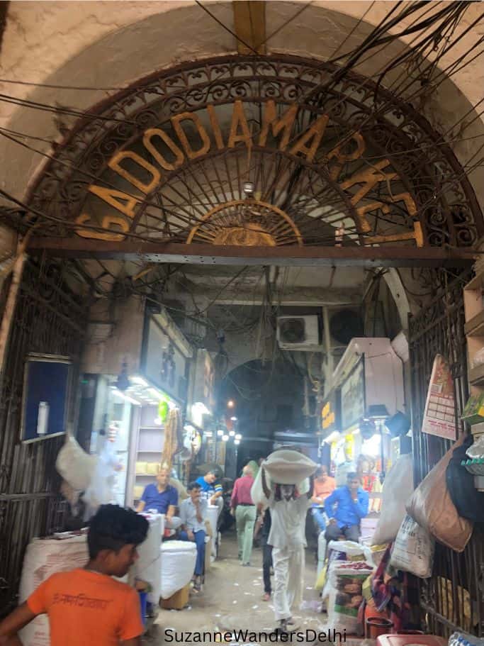 entrance gate to Gadodia Market with giant arch and men walking through