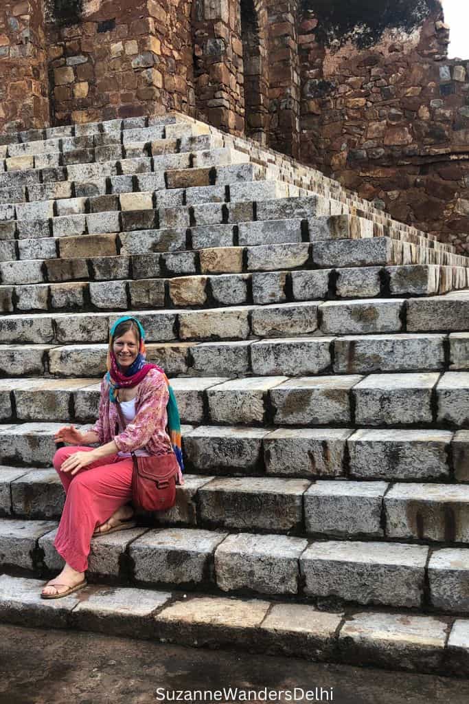 author sitting on stone steps leading to the mosque