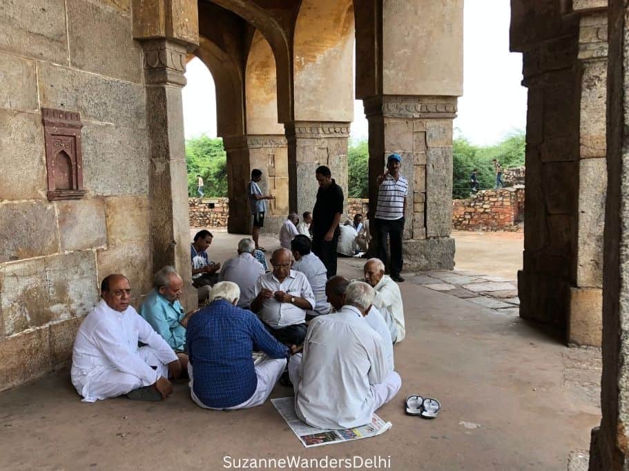groupof older men gambling and card playing under the domes of Bhool Bhulaiya in Mehrauli Village